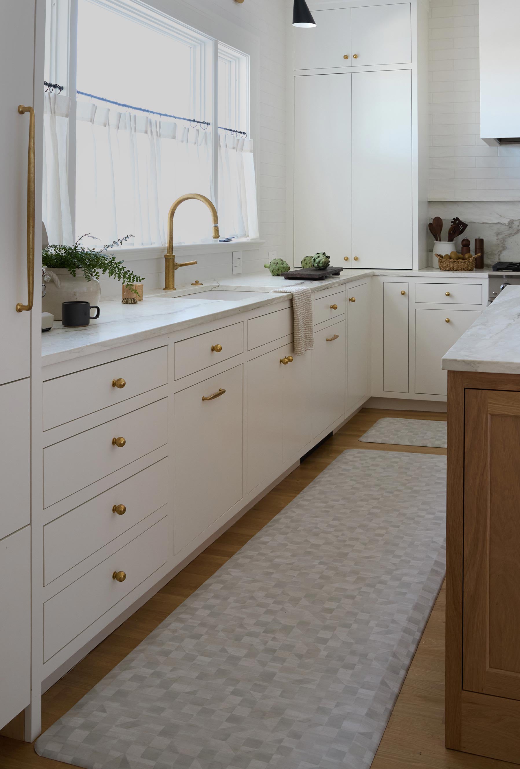 Georgia clay neutral checker print standing mat shown in between a kitchen counter and island in size 30x108