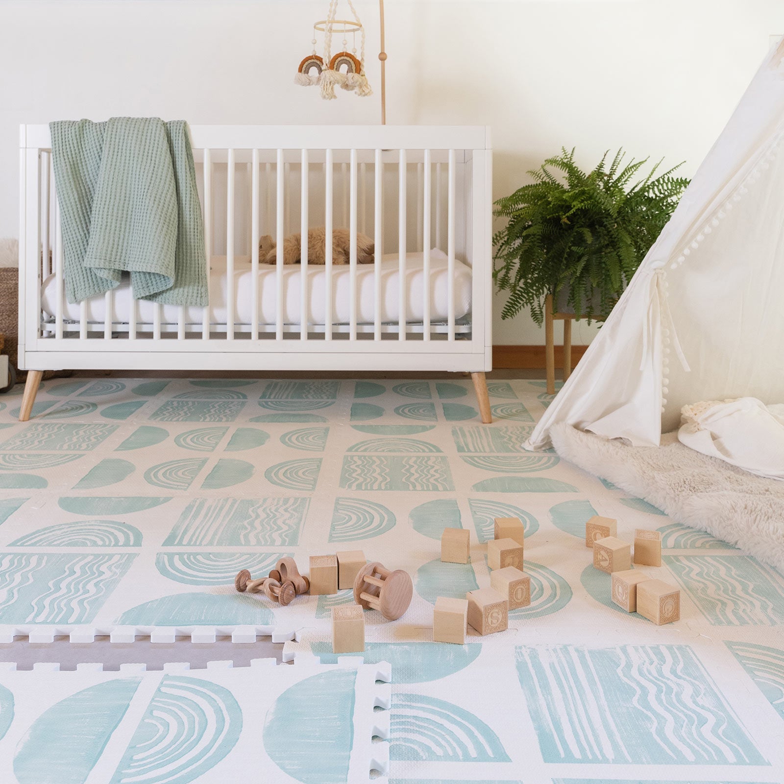 Ada modern minimalist baby play mat in Celadon, pale aqua blue and off white. Shown in nursery with 1 tile lifted and baby blocks.